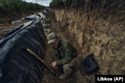 Un soldat ucrainean stă într-un șanț săpat pe linia frontului în apropiere de Bahmut, în regiunea Donețk, Ucraina, 22 mai 2023.