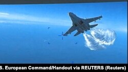 Російський літак Су-27 скидає паливо над американським розвідувальним безпілотником MQ-9 над Чорним морем, 14 березня 2023 року, кадр із відео
