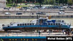 A Clark Ádám úszódaru az elszállítást végző uszályra emeli a balesetben elsüllyedt Hableány turistahajó roncsát Budapesten 2019. június 11-én