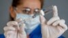 COVID-19 Coronavirus Vaccine. Doctor scientist with syringe analyzing virus Sars-CoV-2 in research for the vaccine.