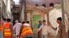 Pakistani volunteers collect debris from a demolished Ahmadi mosque that was demolished by an angry mob on May 24 in the eastern Pakistani city of Sialkot