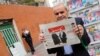 Iranac čita novine na čijoj naslovnoj su aktuelni predsednik Hasan Rohani i bivši predsednik Akbar Hashemi Rafsanjani 