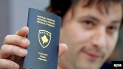 čovek drži u ruci pasoš Kosova