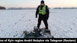 Поліцейський біля частини російської крилатої ракети, збитої українською ППО під час атаки Росії на Україну. Київщина, 5 грудня 2022 року