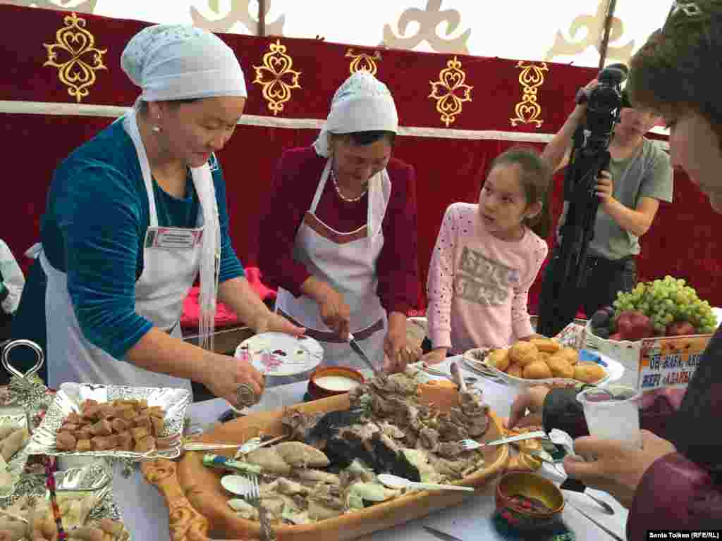 Жительница поселка Бейнеу Алмагуль Есбергенова (слева) привезла на ярмарку и казахское традиционное блюдо из мяса. 