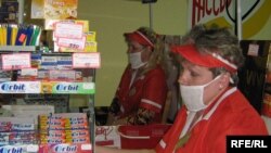 Касіры фірмовай крамы “Сьвітанак” ілюструюць, як ня&nbsp;варта насіць маскі. Маскі мусяць закрываць ня&nbsp;толькі рот, але і&nbsp;нос.