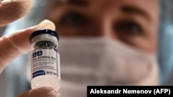 RUSSIA -- A medical worker holds a vial with Russia's Sputnik V vaccine against the coronavirus at a vaccination point at the GUM department store in Moscow, January 18, 2021.