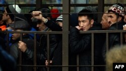 Трудовые мигранты стоят в очереди, чтобы получить разрешение на работу, в Федеральной миграционной службе РФ, Москва, 25 октября 2013 года. 