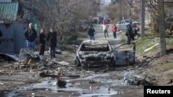 Dnipro residents inspect the aftermath of a Russian drone strike on the Ukrainian city late on March 28.