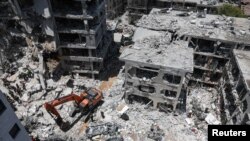 Spasioci na mjestu udara nakon raketnog napada Irana na Izrael, u Bat Jamu, Izrael, 15. juna 2025.