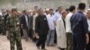 FILE: Ethnic Uighurs, some wearing white flowers, gather before an official ceremony.